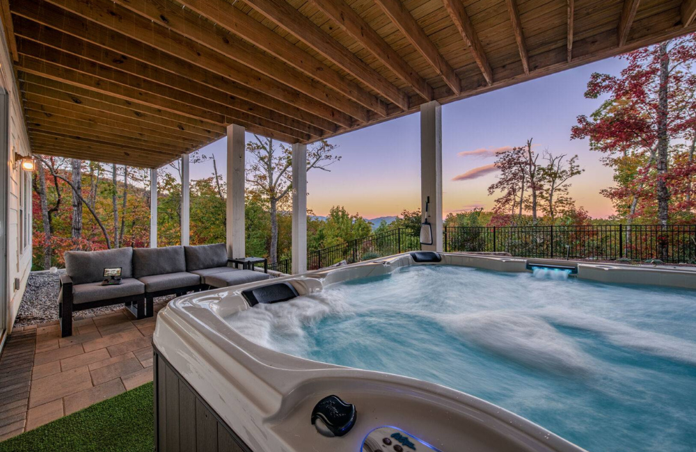 large hot tub with expansive views and sunset in the background Greybeard Vacation Rentals