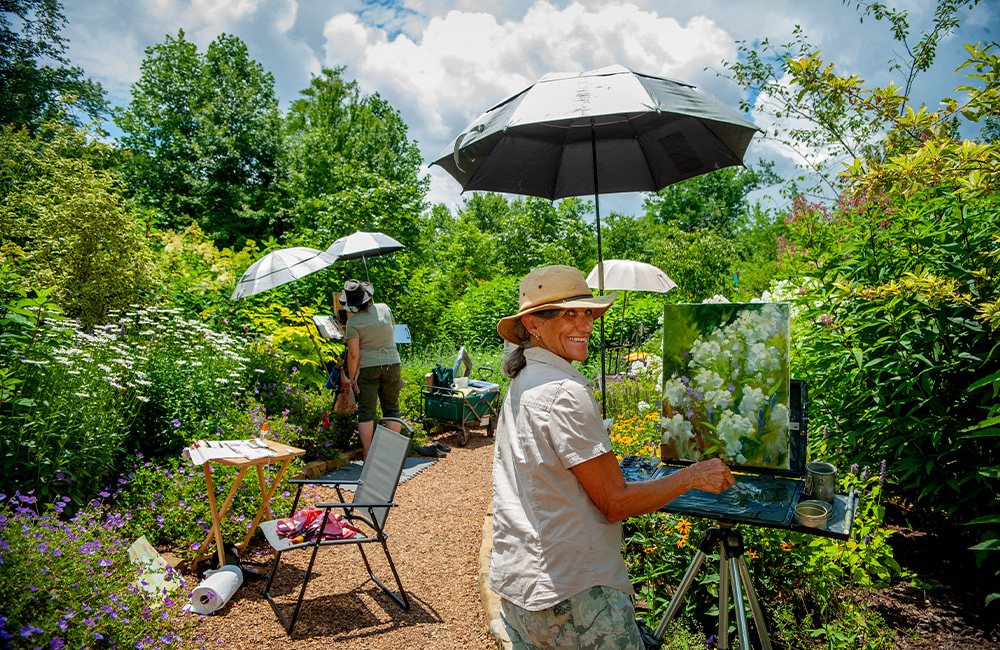 Artist smiling while painting at Cashiers Plein Air Festival