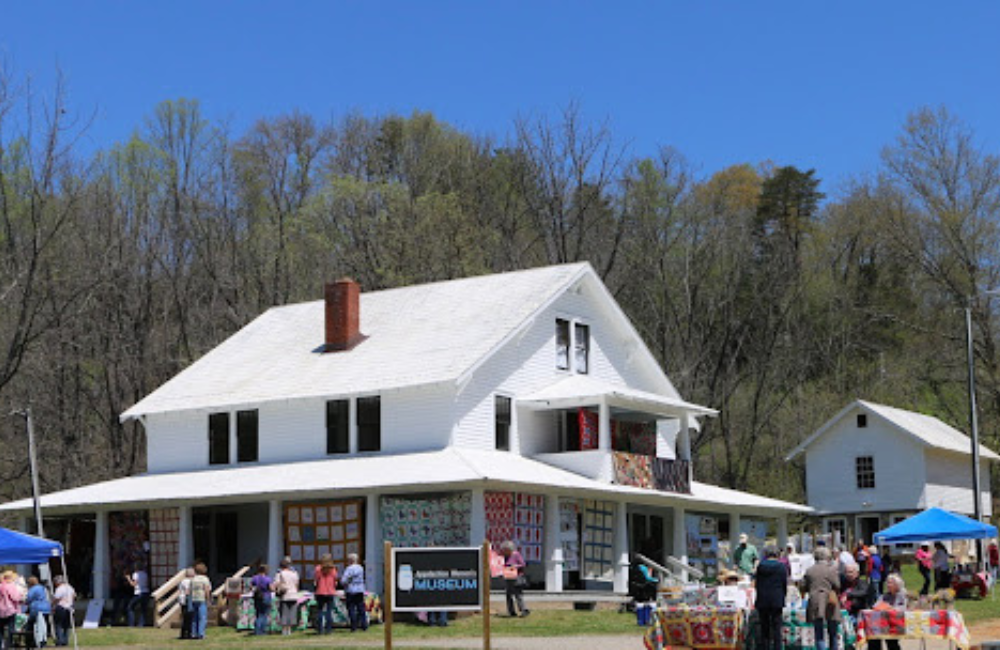 Historic two-story home with quilts hanging in the yard