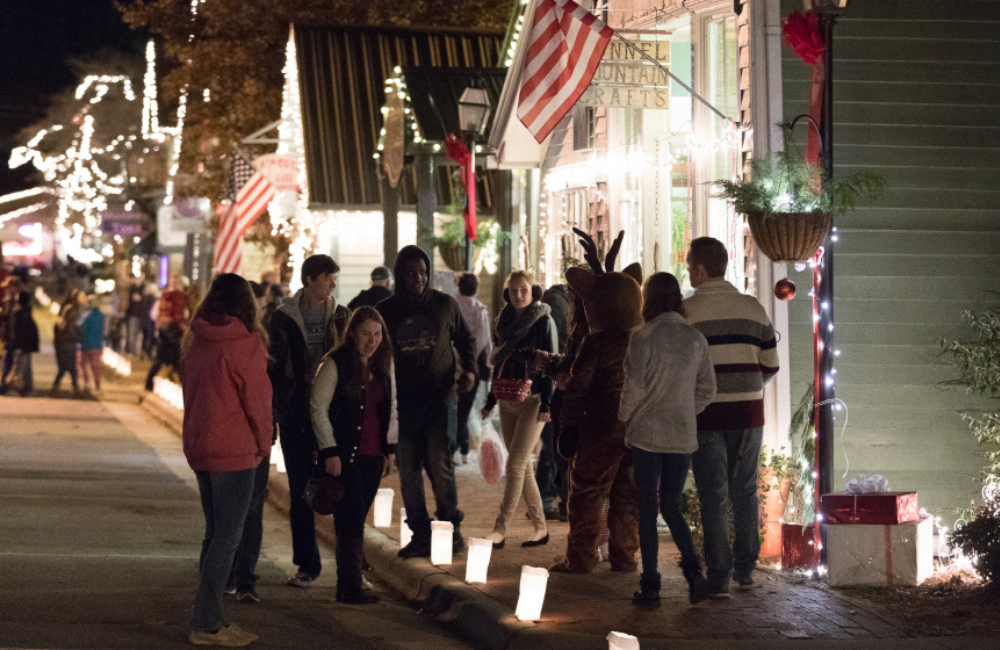 People walking streets lit my candles and lights during the holidays