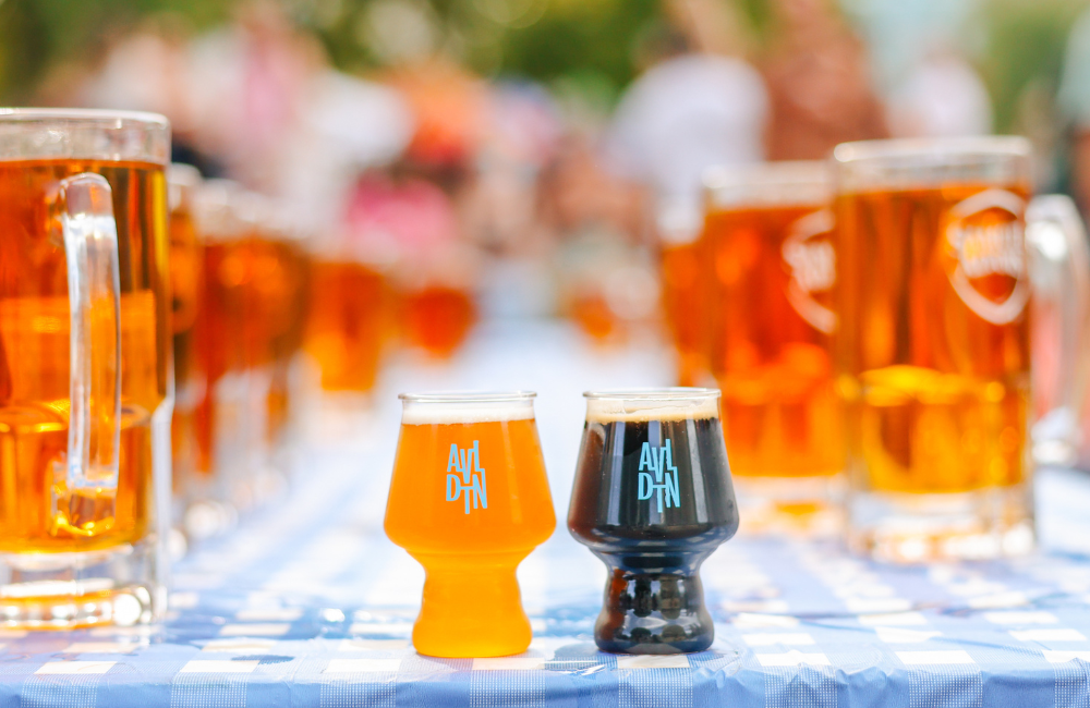 Beer steins lined up on a Bavarian style table cloth