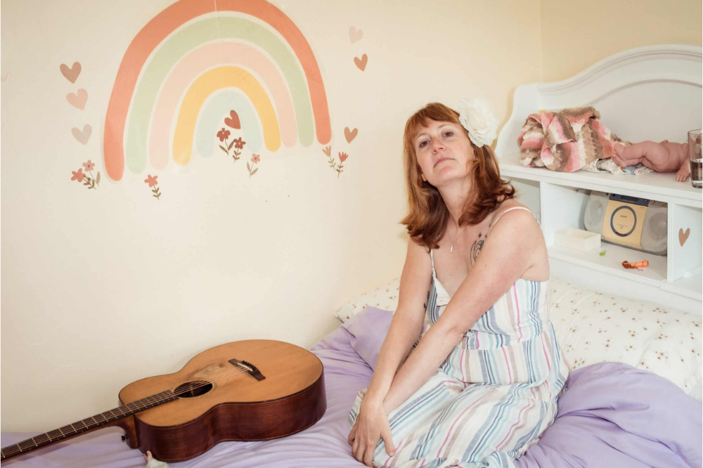 Woman posting with a guitar for Amanda Platt and the Honey Cutters