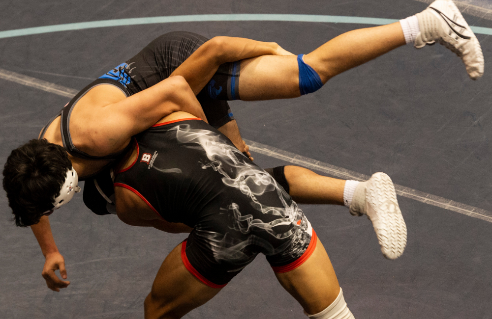 Wrestler lifts and tosses another wrestler