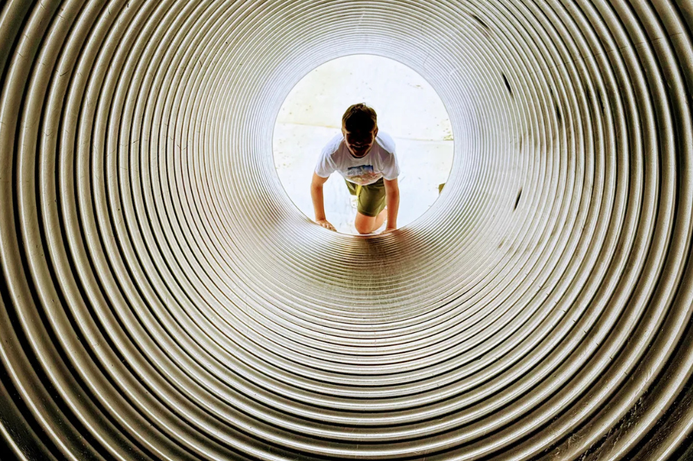 Child crawling through a tunnel at the corn maze