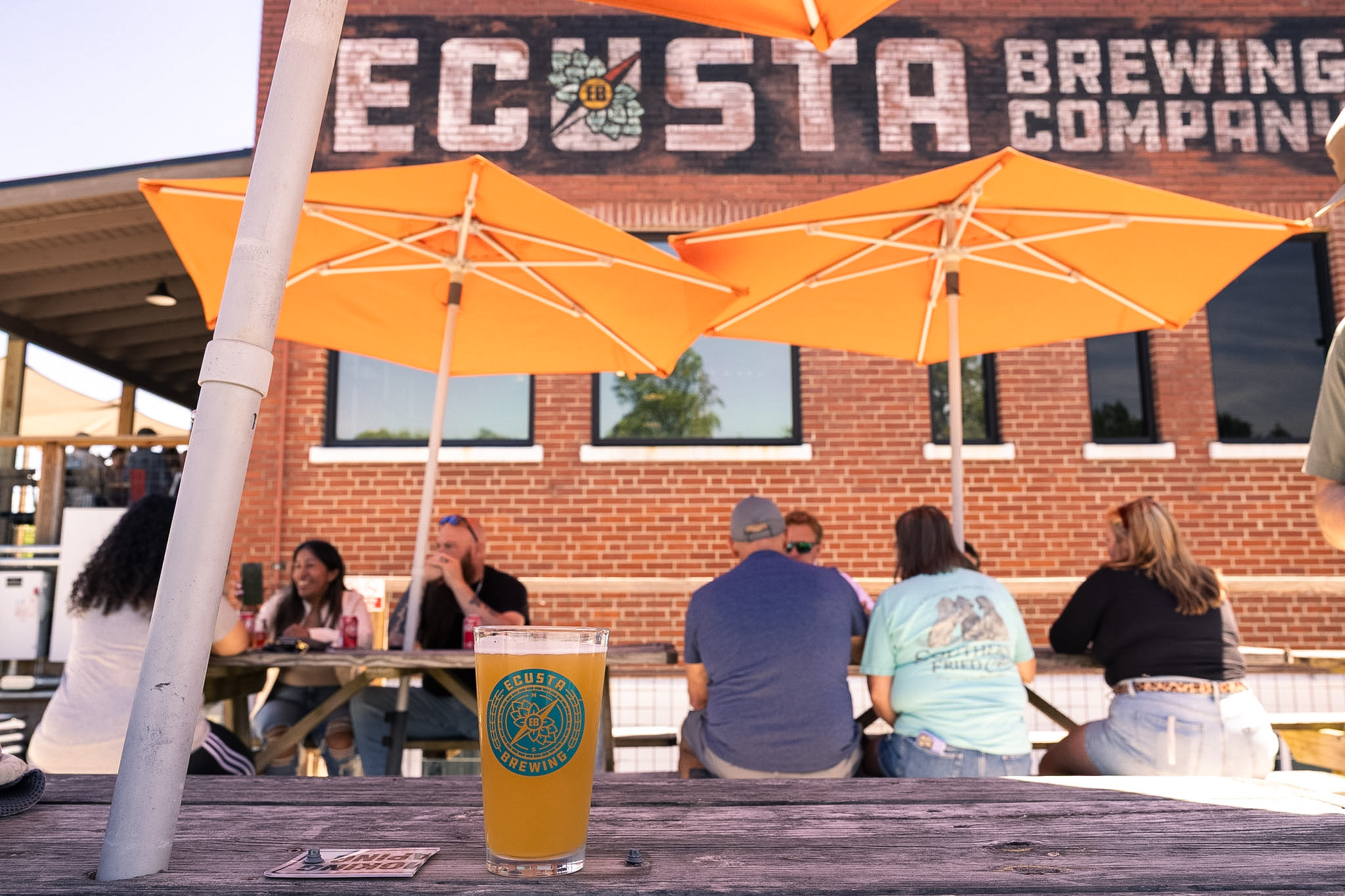 People sitting at tables outside Ecusta Brewing