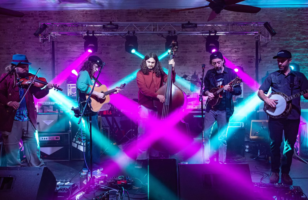 A five-member band playing instruments on a stage